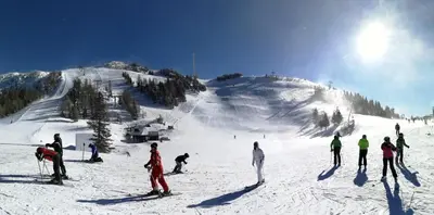 a group of people skiing down a snow covered slope at Cottage House Jakob in Cerklje na Gorenjskem
