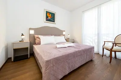 a bedroom with a bed and a table and a chair at Villa Mihaela in Bled