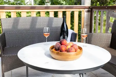 a bowl of fruit on a table with two glasses of wine at Villa Mihaela in Bled