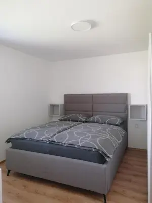 a bedroom with a bed in a white room at Apartment Sunset in Maribor