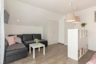 a living room with a black couch and a table at Apartments Fine Stay Slovenia in Žirovnica
