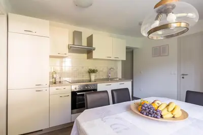 a kitchen with a table with a bowl of fruit on it at Apartments Fine Stay Slovenia in Žirovnica