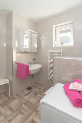 a white bathroom with a sink and a toilet and a sink at Apartments Fine Stay Slovenia in Žirovnica