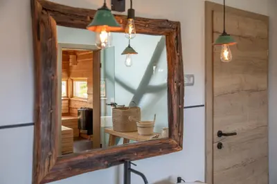 a mirror with a wooden frame hanging over a sink at Hiska B&N Podlehnik in Podlehnik