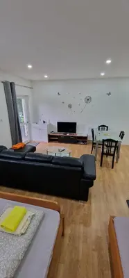 a living room with a black couch and a table at Apartman MURKO P-2 in Brest