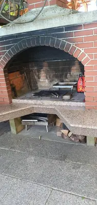 a brick oven with a bench in front of it at Apartman MURKO P-2 in Brest