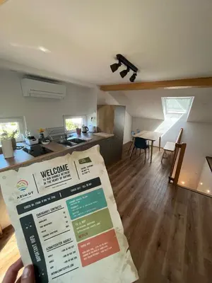 a person is holding a package in front of a kitchen at Azimut Hiša in Tolmin