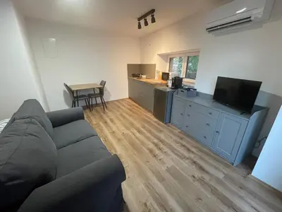 a living room with a couch and a kitchen at Azimut Hiša in Tolmin