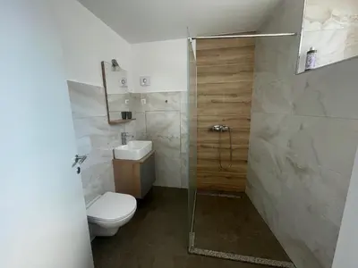 a bathroom with a toilet and a glass shower at Azimut Hiša in Tolmin