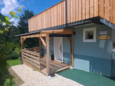 a house with a wooden porch with a deck at GreenRiver Apartment in Spodnje Gorje