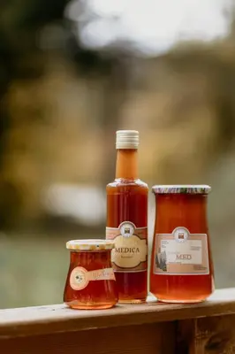 two bottles of honey sitting on a table at GreenRiver Apartment in Spodnje Gorje