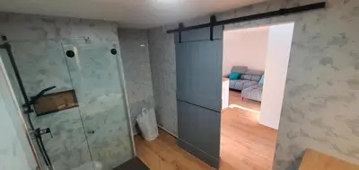 a bathroom with a shower and a couch in a room at Weekend House Solis - Bovec in Bovec