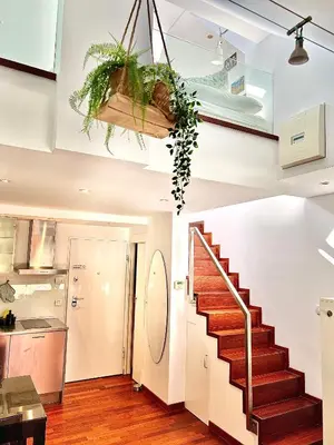 a staircase in a living room with wooden floors at Galleria apartment Ljubljana in Ljubljana