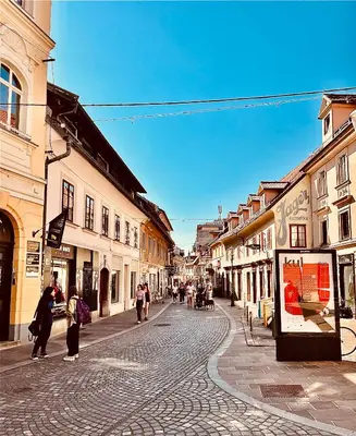 a group of people walking down a street with buildings at Galleria apartment Ljubljana in Ljubljana