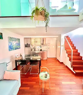 a living room with a staircase and a kitchen at Galleria apartment Ljubljana in Ljubljana