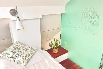 a bedroom with a bed and a green wall at Galleria apartment Ljubljana in Ljubljana