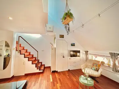 a living room with a staircase and a couch at Galleria apartment Ljubljana in Ljubljana