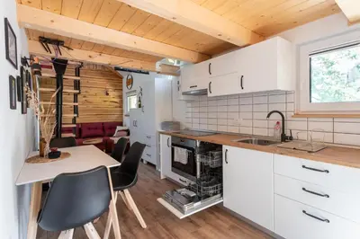 a kitchen with white cabinets and a table and chairs at Lavender Lodge Bled in Bled