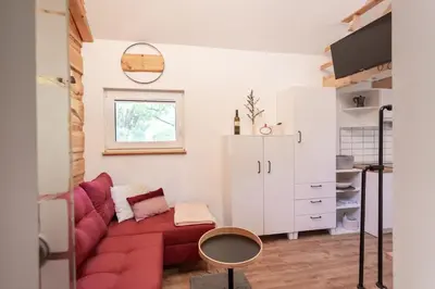 a living room with a red couch and a window at Lavender Lodge Bled in Bled