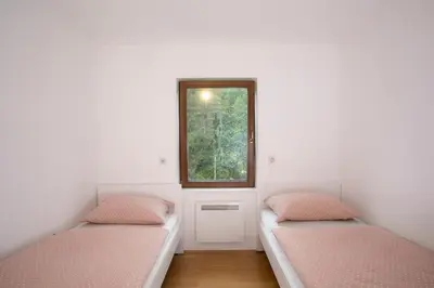 two beds in a room with a window at Apartment Vera Kranjska Gora in Kranjska Gora