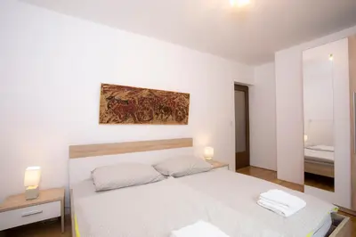 a white bedroom with a bed with two towels on it at Apartment Vera Kranjska Gora in Kranjska Gora
