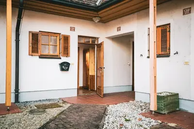 an open door of a white house with windows at POČITNIŠKI APARTMAJI - Trobentica 37 Apartment Golf Moravske Toplice in Moravske Toplice