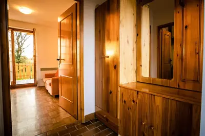 a hallway with a wooden cabinet and a living room at POČITNIŠKI APARTMAJI - Trobentica 37 Apartment Golf Moravske Toplice in Moravske Toplice