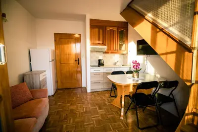 a small kitchen with a table and chairs in a room at POČITNIŠKI APARTMAJI - Trobentica 37 Apartment Golf Moravske Toplice in Moravske Toplice
