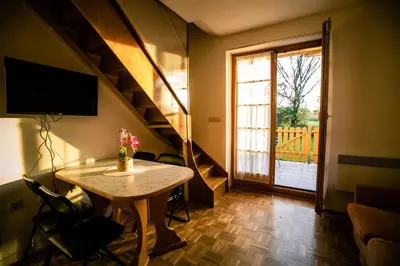 a small living room with a table and a staircase at POČITNIŠKI APARTMAJI - Trobentica 37 Apartment Golf Moravske Toplice in Moravske Toplice