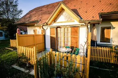 a small white house with a wooden fence at POČITNIŠKI APARTMAJI - Trobentica 37 Apartment Golf Moravske Toplice in Moravske Toplice
