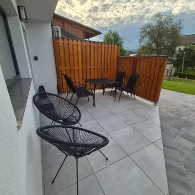 a patio with chairs and a table and a fence at Annie's apartment in Bled