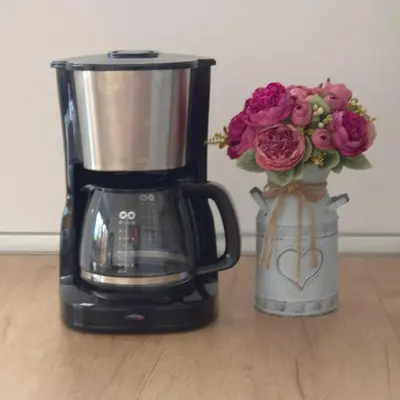 a coffee maker and a vase of flowers on a table at Annie's apartment in Bled