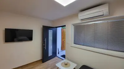 a room with a door and a window and a television at Annie's apartment in Bled