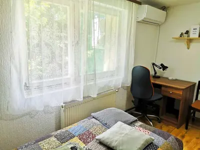 a bedroom with a bed and a desk and a window at Small house in Celje in Celje