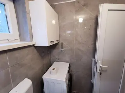 a bathroom with a toilet and a white cabinet at Small house in Celje in Celje
