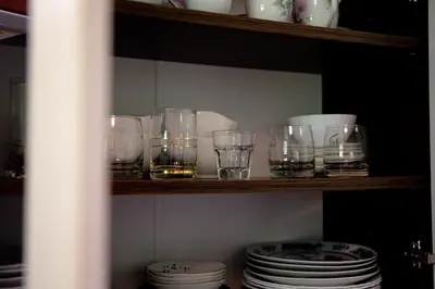a shelf with glasses and plates on it at Elegant House in a Beautiful Village in Cerklje ob Krki