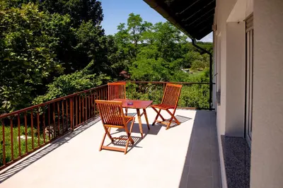 a patio with two chairs and a table on a balcony at Elegant House in a Beautiful Village in Cerklje ob Krki