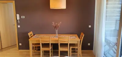 a dining room table with chairs and a vase of flowers at Mari 14 in Maribor