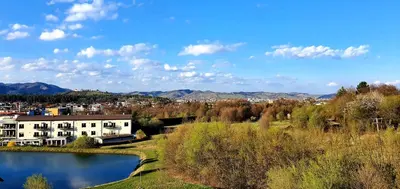 a building next to a lake with a town in the background at Mari 14 in Maribor