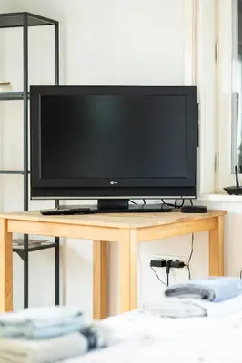 a flat screen tv sitting on top of a wooden table at Nice family friendly apartment in the city center in Ljubljana