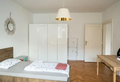 a bedroom with a bed and a table and a mirror at Nice family friendly apartment in the city center in Ljubljana