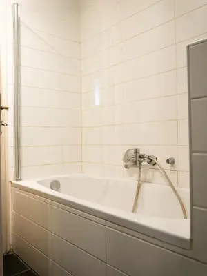 a bath tub with a shower in a bathroom at Nice family friendly apartment in the city center in Ljubljana