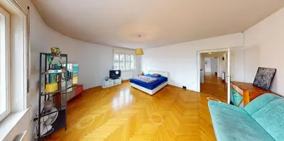 a living room with a bed and a wooden floor at Nice family friendly apartment in the city center in Ljubljana