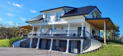 a large white house with a large balcony at Villa Hojnik in Videm pri Ptuju