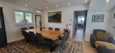 a dining room with a wooden table and chairs at Villa Hojnik in Videm pri Ptuju