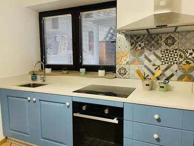 a kitchen with blue cabinets and a sink at Family Home Kobarid - Soca and Nadiza apartament in Kobarid