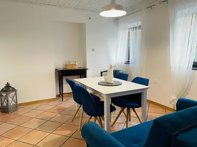 a dining room with a table and blue chairs at Family Home Kobarid - Soca and Nadiza apartament in Kobarid