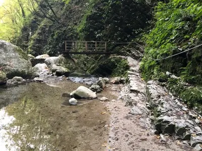 a bridge over a river with rocks and a bridge at Family Home Kobarid - Soca and Nadiza apartament in Kobarid