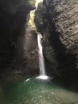 a waterfall in a pool of water in a cave at Family Home Kobarid - Soca and Nadiza apartament in Kobarid