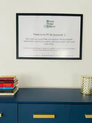 a picture on a wall with a blue dresser with books at Family Home Kobarid - Soca and Nadiza apartament in Kobarid